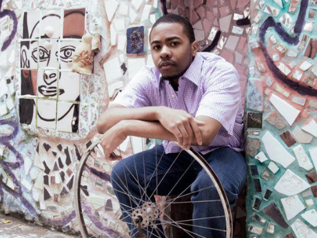 Cortney Lamar Charleston leaning on a bicycle wheel