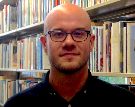 Danniel Schoonebeek standing in front of a bookcase