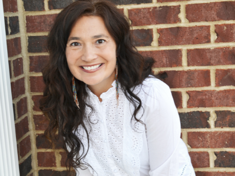 Felicia Zamora standing before a brick wall.