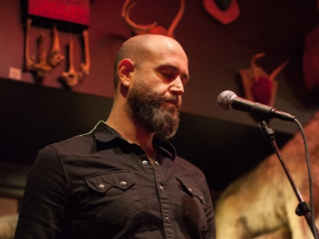 Janaka Stucky standing before a microphone